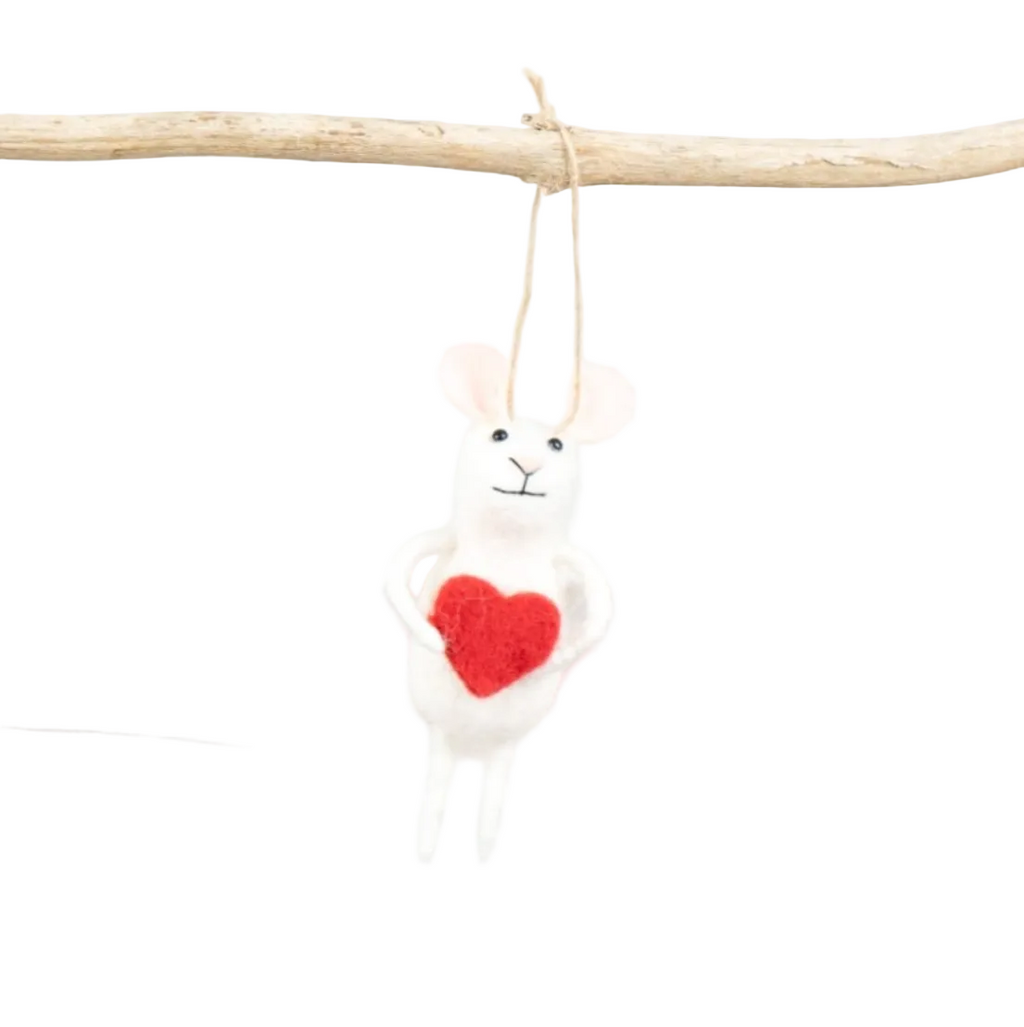 White plush toy with a red heart on a wooden branch against a white background