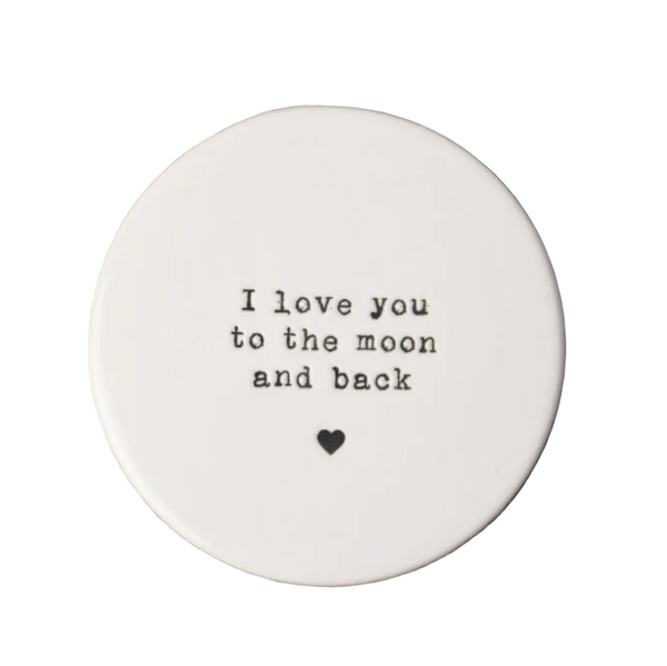 Round white ceramic coaster with 'I love you to the moon and back' text on a white background.