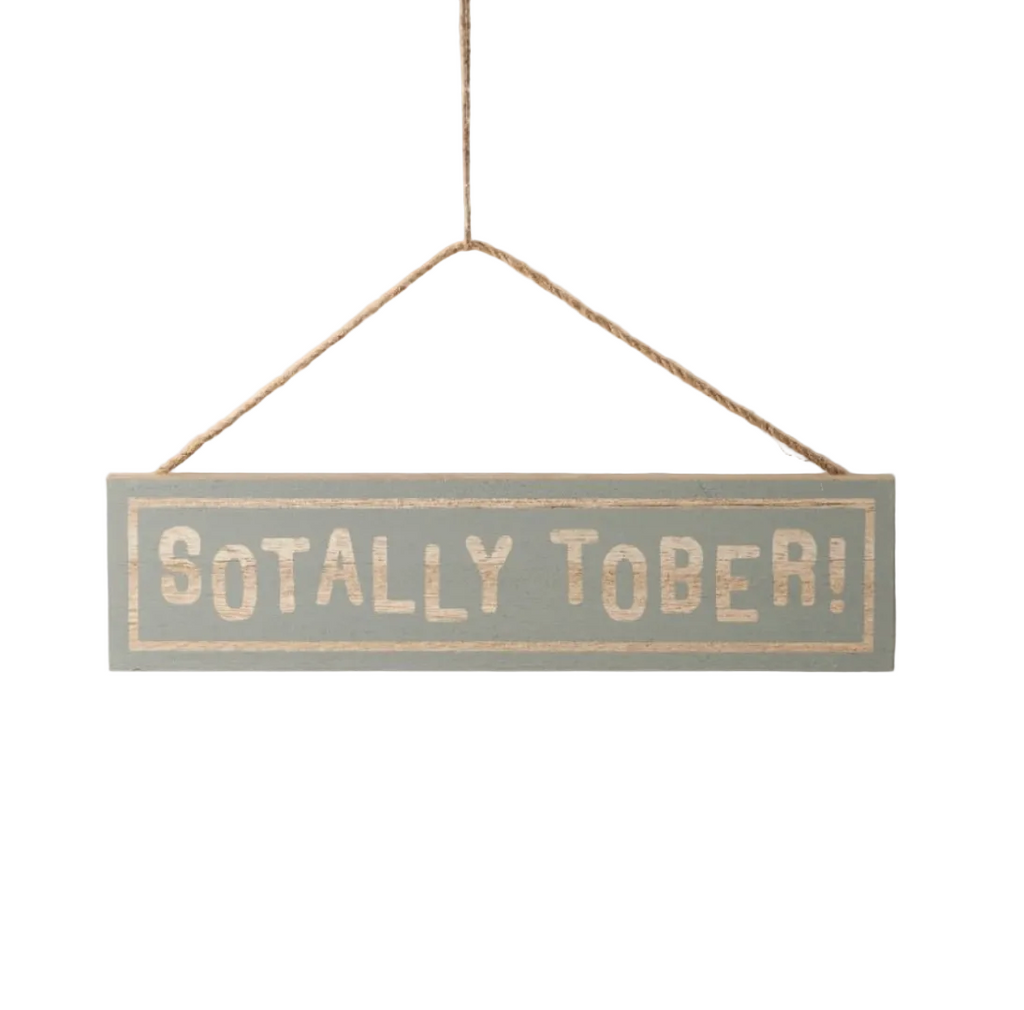 Hanging wooden sign saying 'Sotally Tober' on a white background