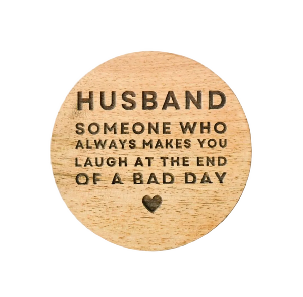 Wooden round plaque with engraved text on a wooden surface