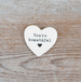 Heart-shaped stone with 'You're beautiful' text on a wooden surface