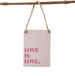 Fabric sign with 'LOVE IS LOVE.' text hanging on a branch against a white background