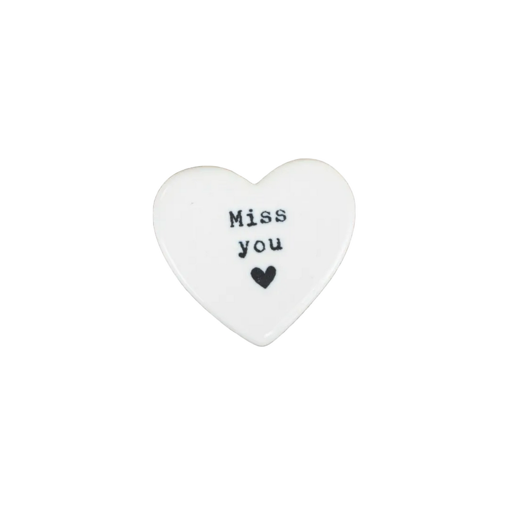 Heart-shaped white object with 'Miss you' text on a white background