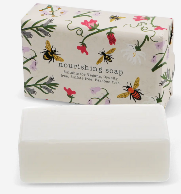 Bar of soap with a decorative packaging featuring bees and flowers on a white background.