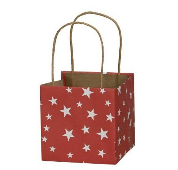 Red paper gift bag with white star pattern and brown handles on a white background