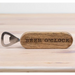 Wooden bottle opener with 'BEER O'CLOCK' engraving on a light wooden background