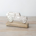 Silver car figurine on a wooden base against a light background