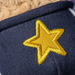 Navy blue fabric with a yellow embroidered star on a plush toy background