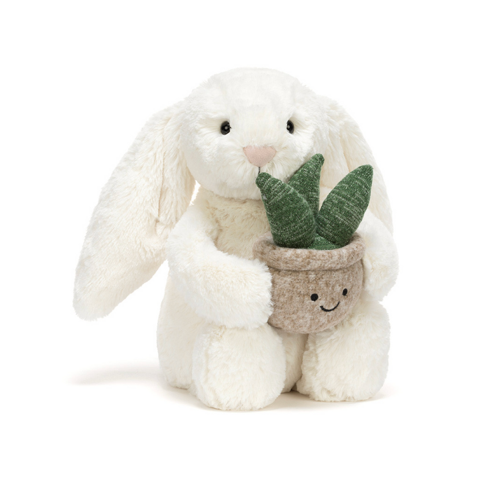 White plush bunny holding a small potted plant on a white background