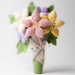 Plush toy resembling a bouquet of flowers with a smiling face on a white background