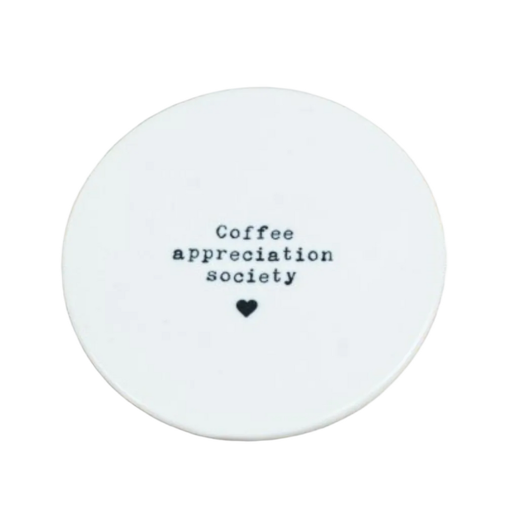 Round white coaster with 'Coffee appreciation society' text on a white surface