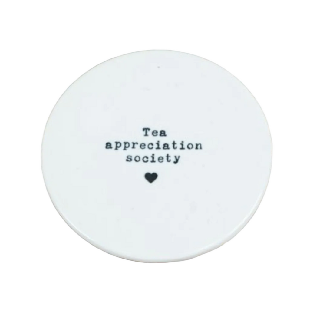 Round white coaster with 'Tea appreciation society' text on a white surface