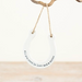 Round white sign with text 'All you need is love and a horse' hanging on a wooden surface.
