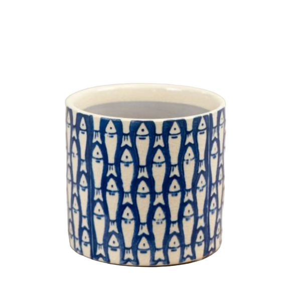 Ceramic mug with fish pattern on a white surface