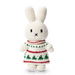A crocheted bunny plush toy wearing a festive Christmas sweater with green trees and red patterns, set against a plain white background.