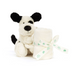 A plush puppy toy in cream and black sitting next to a rolled cream baby towel tied with a cream ribbon printed with green paw prints and the text 'BABY BABY BABY'.