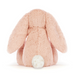 A plush bunny toy photographed from the back, featuring soft peach-pink fur and a small white fluffy tail, set against a clean white background.