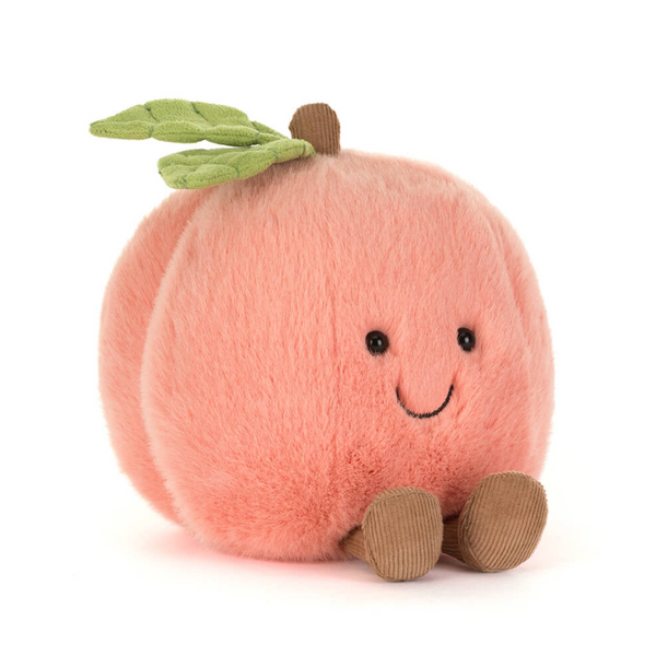 A plush peach toy with a soft pink body, green leaves on top, a small brown stem, embroidered black eyes and smile, and brown corduroy feet, photographed on a clean white background.