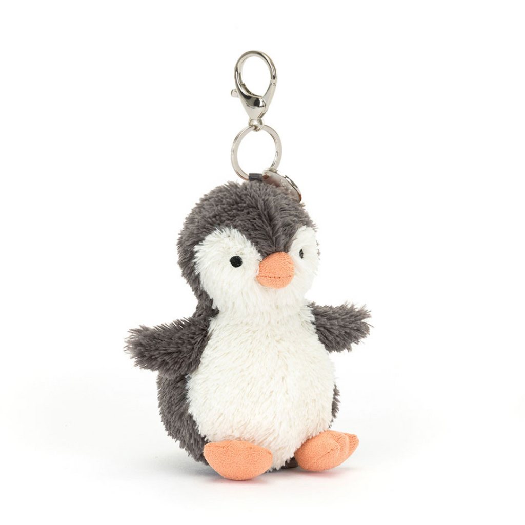 A plush penguin keychain with a gray and white body, orange beak and feet, and a silver metal clasp on a white background.