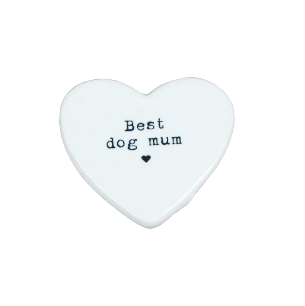 A white heart-shaped ceramic plaque with the text 'Best dog mum' and a small heart printed in black, displayed on a light-colored wooden surface.