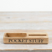 Wooden tray with 'POCKET STUFF' engraving on a light wooden surface
