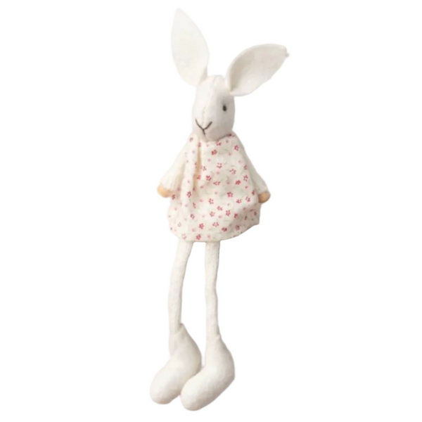 A white felt rabbit doll wearing a cream dress with small pink floral print, against a white background.