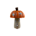 A small decorative mushroom-shaped house figurine with an orange-brown pumpkin cap, a tan wooden-looking stem, and tiny black-and-white window details, on a white background.