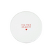A round white ceramic coaster with the phrase 'TIS THE SEASON' and a small red heart printed in the center.