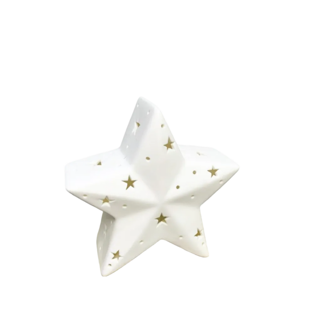 A white ceramic star-shaped candle holder with gold star cutouts.