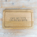 A rectangular wooden cutting board with rounded corners and a raised rim, featuring the engraved text 'OFF MY TITS ON PICKY BITS' in dark lettering. The board is photographed from directly above on a light-colored wooden surface.