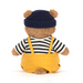 Teddy bear wearing a navy hat, striped shirt, and yellow overalls on a white background