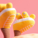 Yellow baby skates with white soles on a pink background