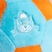 Close-up of a plush toy with a cat face design on a blue and orange background