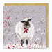 Christmas card with a sheep wearing a red bow, surrounded by flowers and berries on a gray background.