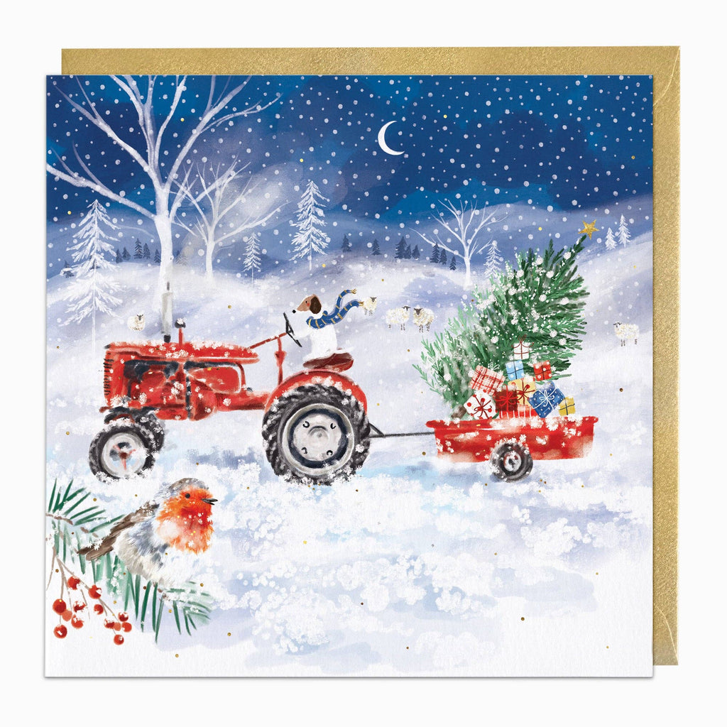 Christmas card with a red tractor pulling a trailer with a Christmas tree and presents through a snowy landscape.
