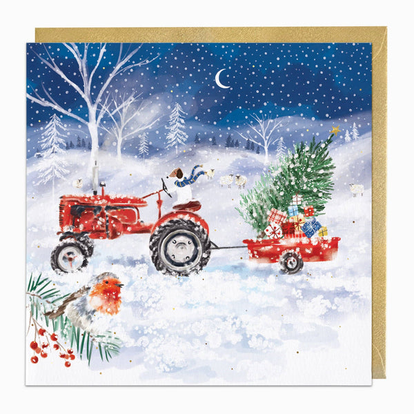 Christmas card with a red tractor pulling a trailer with a Christmas tree and presents through a snowy landscape.