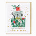 A square Christmas greeting card with a gold border, featuring an illustration of stacked gift boxes with green holly leaves, red berries, gold stars, and the text 'to our wonderful Son with so much love at Christmas'.