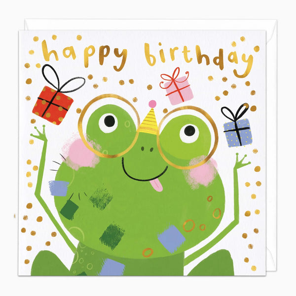 A square children's birthday card featuring a green cartoon frog wearing round glasses and a party hat, with gold 'happy birthday' text, gold polka dots, and small wrapped presents in red, pink, and blue on a white background.