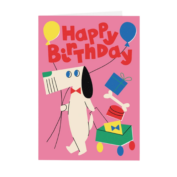 Mrs Best Paper Co. cubist dog birthday card with vibrant balloons, gifts, and a wagon on a pink background