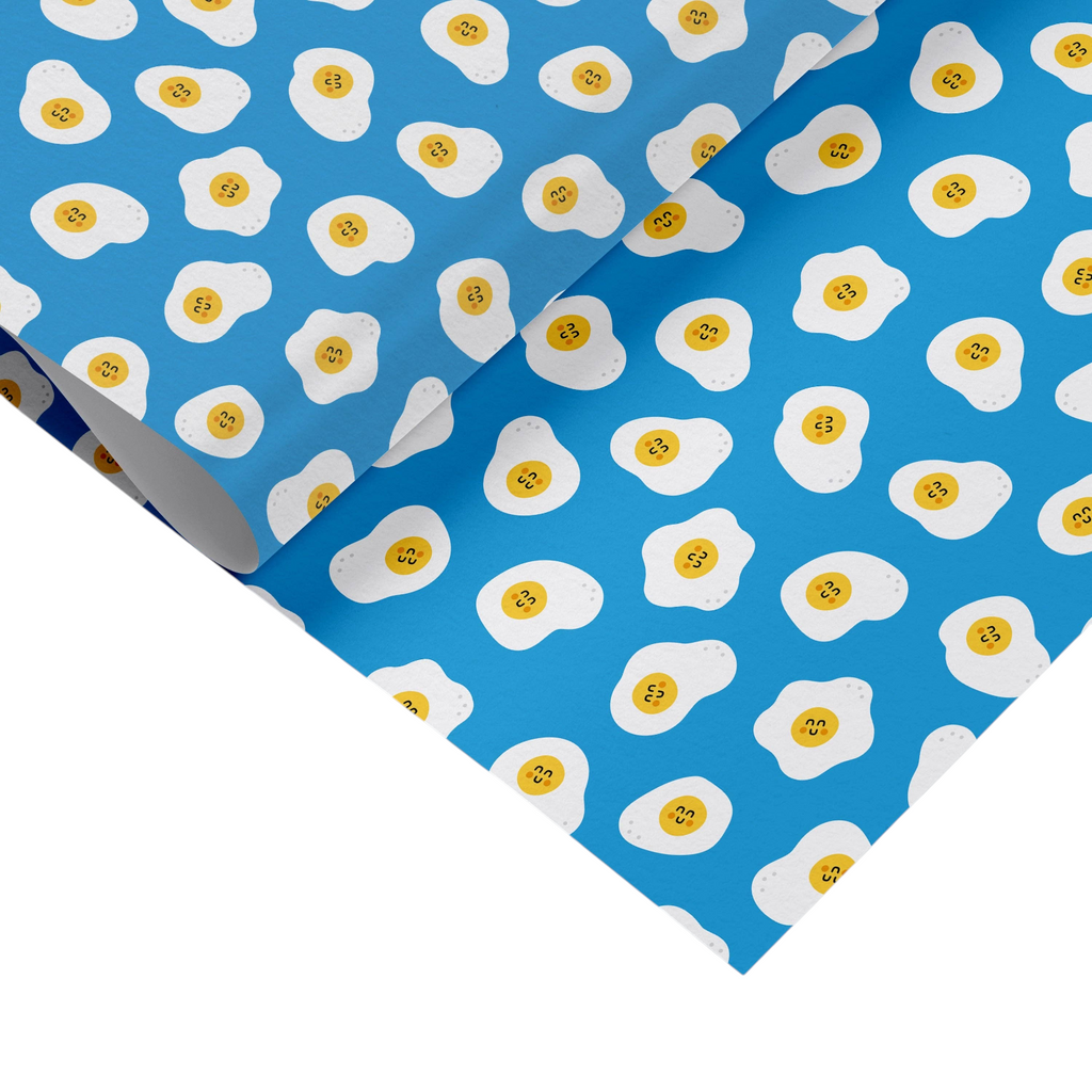 Mrs Best Paper Co. matte gift wrap featuring a blue background with a repeating pattern of cute smiling fried eggs.
