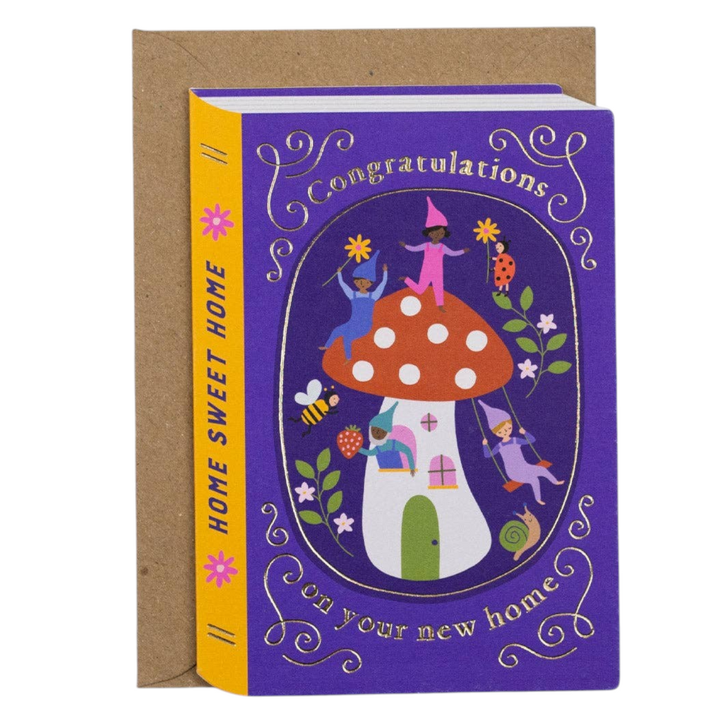 Mrs Best Paper Co. die-cut book-shaped housewarming card featuring a gnome and mushroom illustration with gold foil.