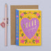 Mrs Best Paper Co. storybook engagement card with floral print, purple heart, and gold foil text on a kraft envelope.