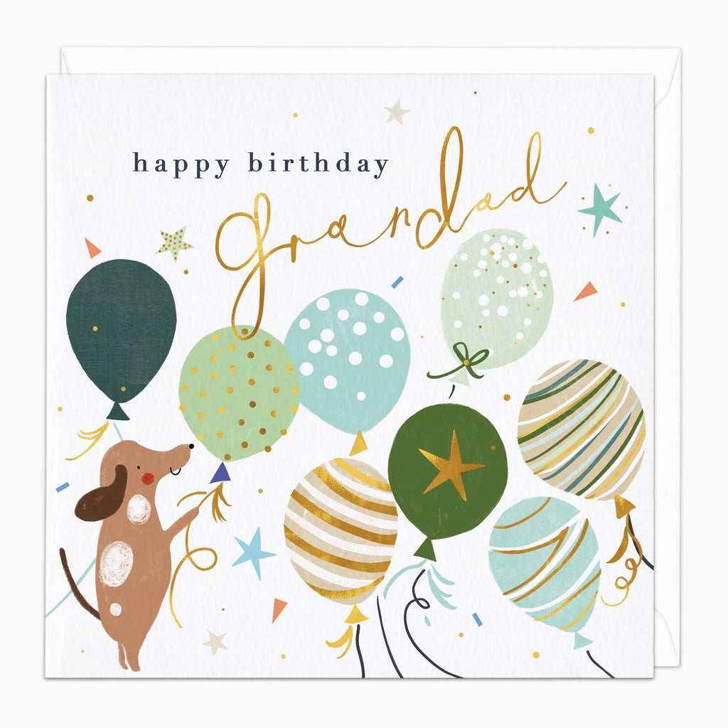A square birthday card with a white background featuring the text 'happy birthday Grandad' in black and gold script. The card is decorated with illustrated balloons in green, blue, beige, and gold patterns, along with small stars and confetti.
