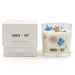 Botanical candle with floral design and matching box labeled 'Agnes + Cat' on a white background
